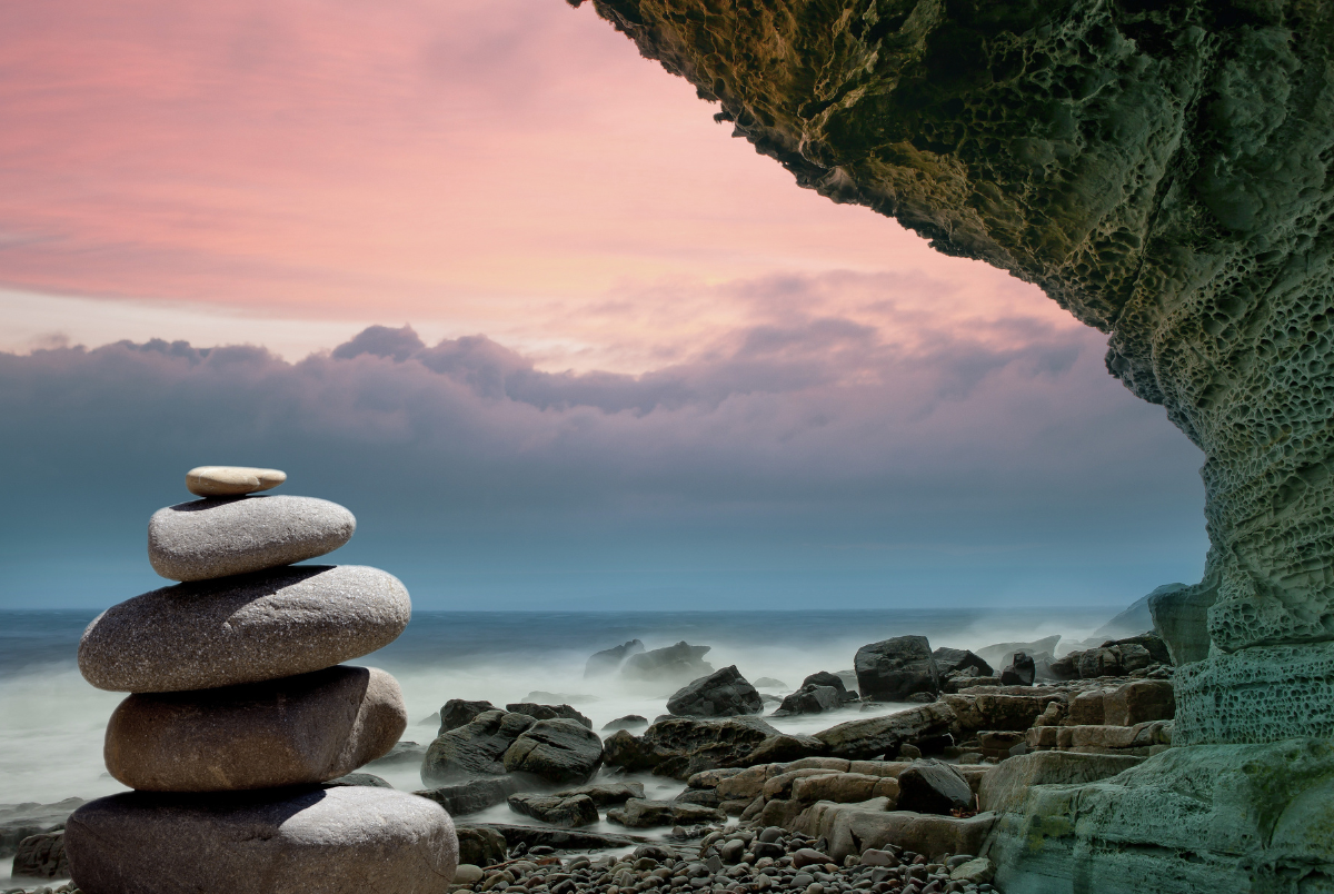 balancing rocks on beach at sunrise