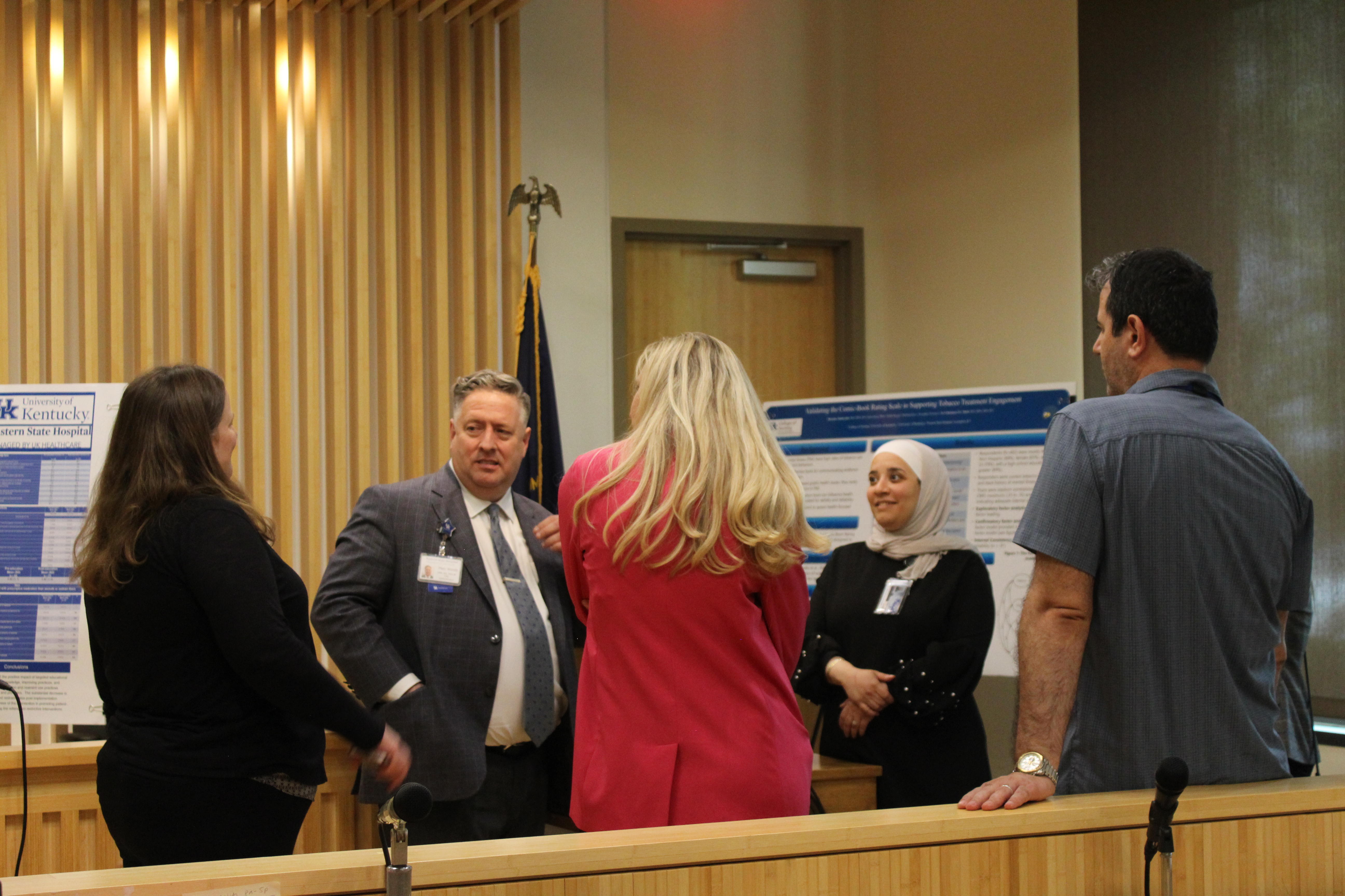 bassema presenting her poster to a group of people