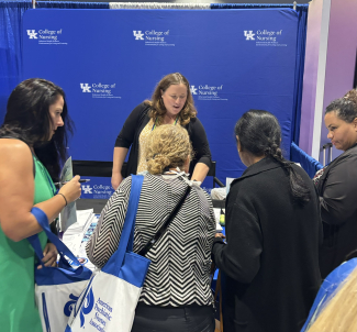 Conference attendees visiting the BH WELL table