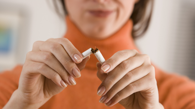 woman snaps cigarette in half