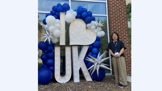 photo of hua kang next to I heart UK letters with balloons