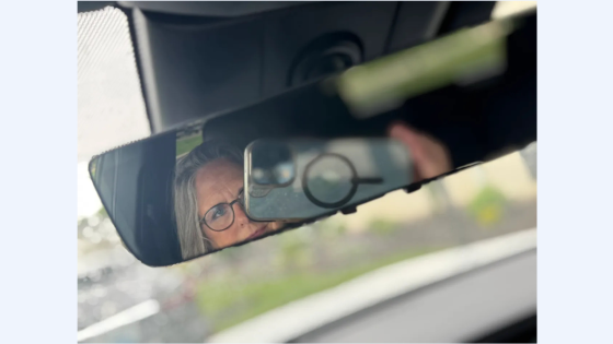 lady taking selfie in rear view mirror