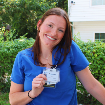 photo of meaghan holding her nursing student badge