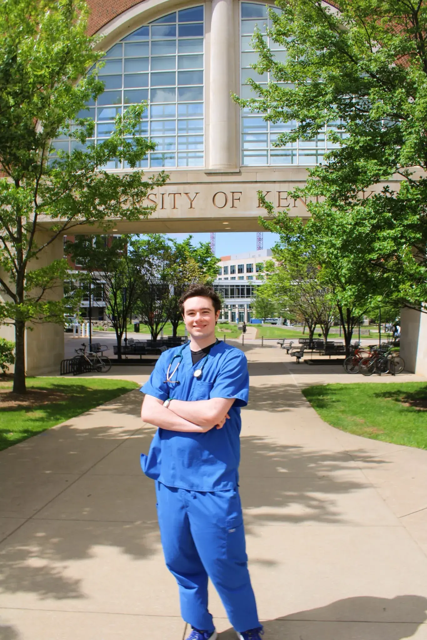 Photo of Shane: young, tall, brunette, in royal blue scrubs standing outside near UK Chandler hospital